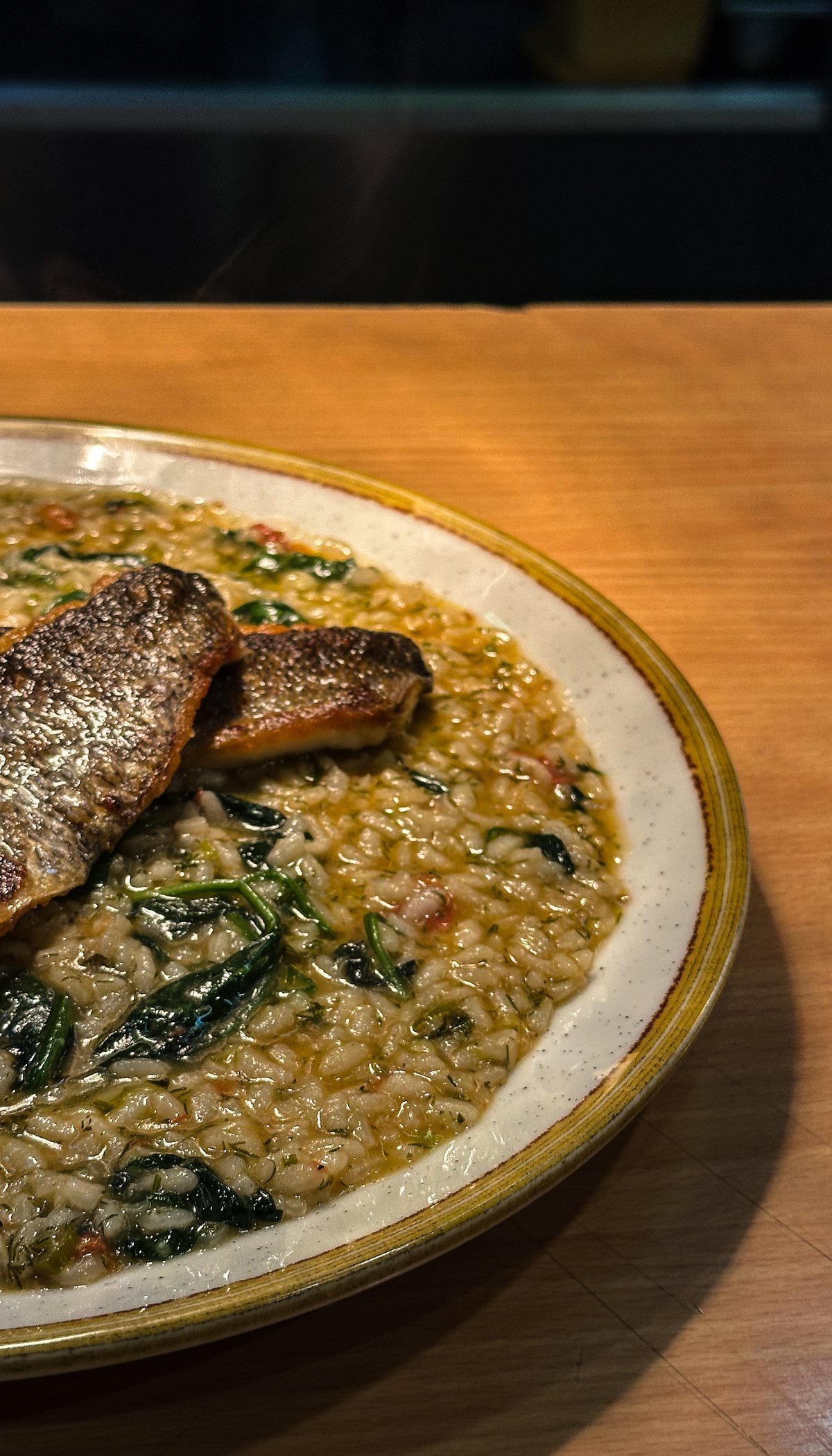 A fillet of sea bass on spinach risotto, close up on the plate