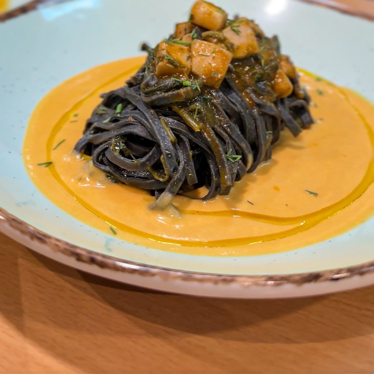 Squid ink tagliatelle with cuttlefish on a saffron sauce