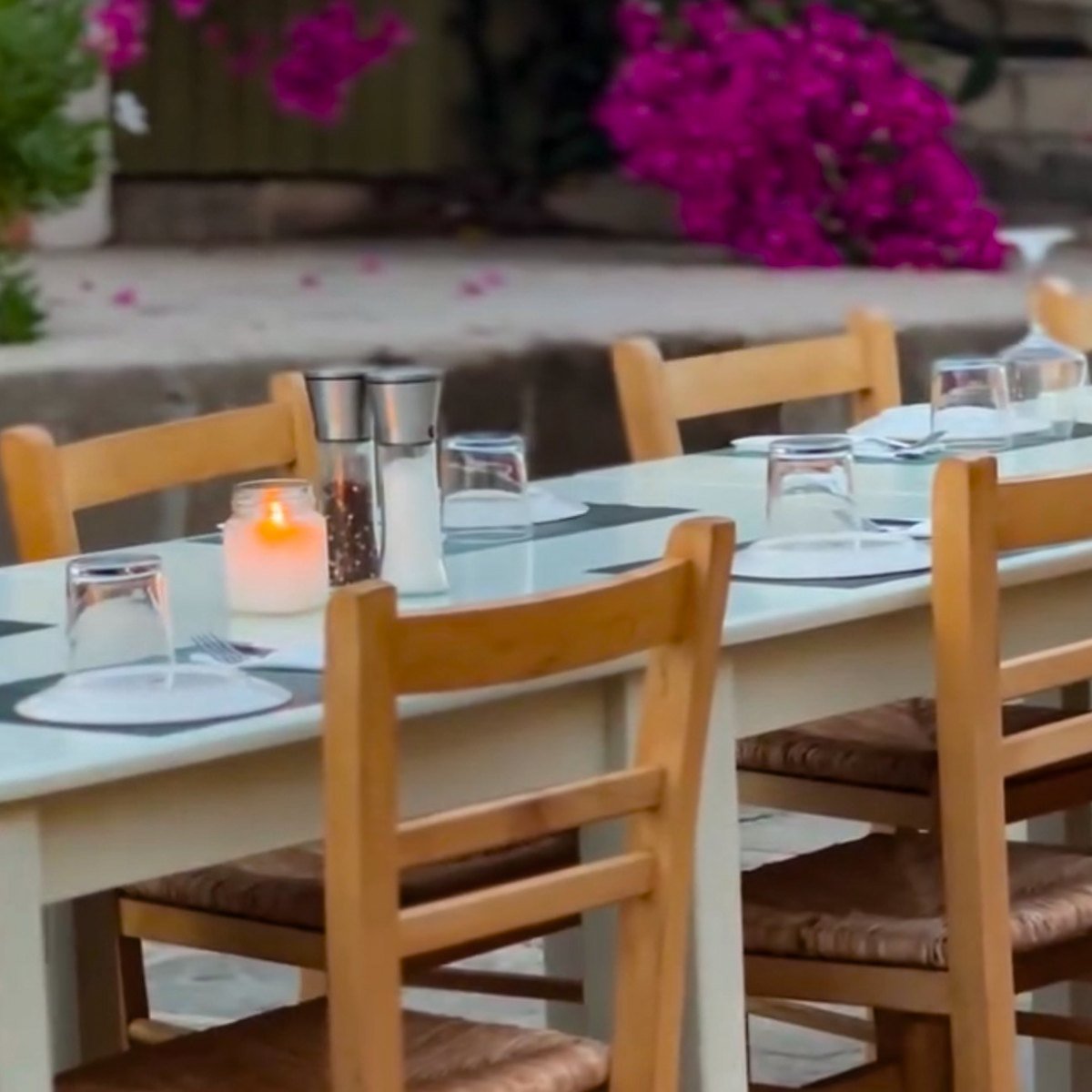 Tables set outside under a bougainvillea in flower