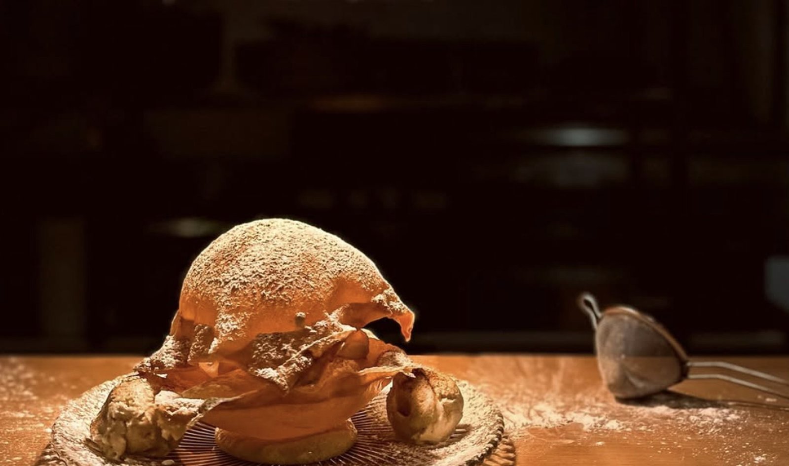 Bougatsa dusted with icing sugar, plated on a dark table